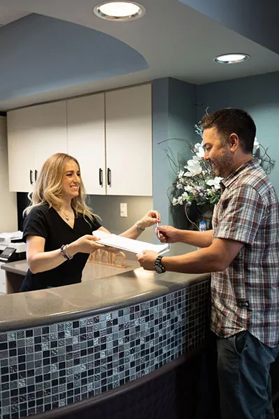 new patient receiving his documents at Radiant Family Dentistry 