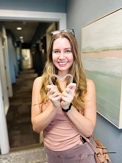 patient forming a heart with her new Invisalign clear aligners