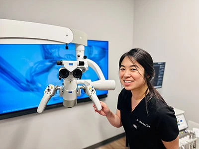 Dr. Christine Chan smiling with dental equipment